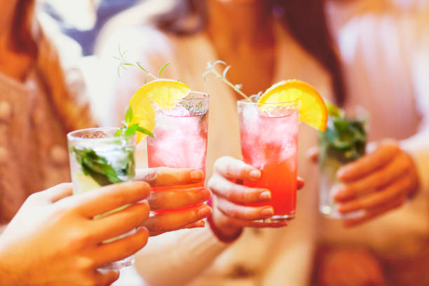Hands holding cocktails at a party